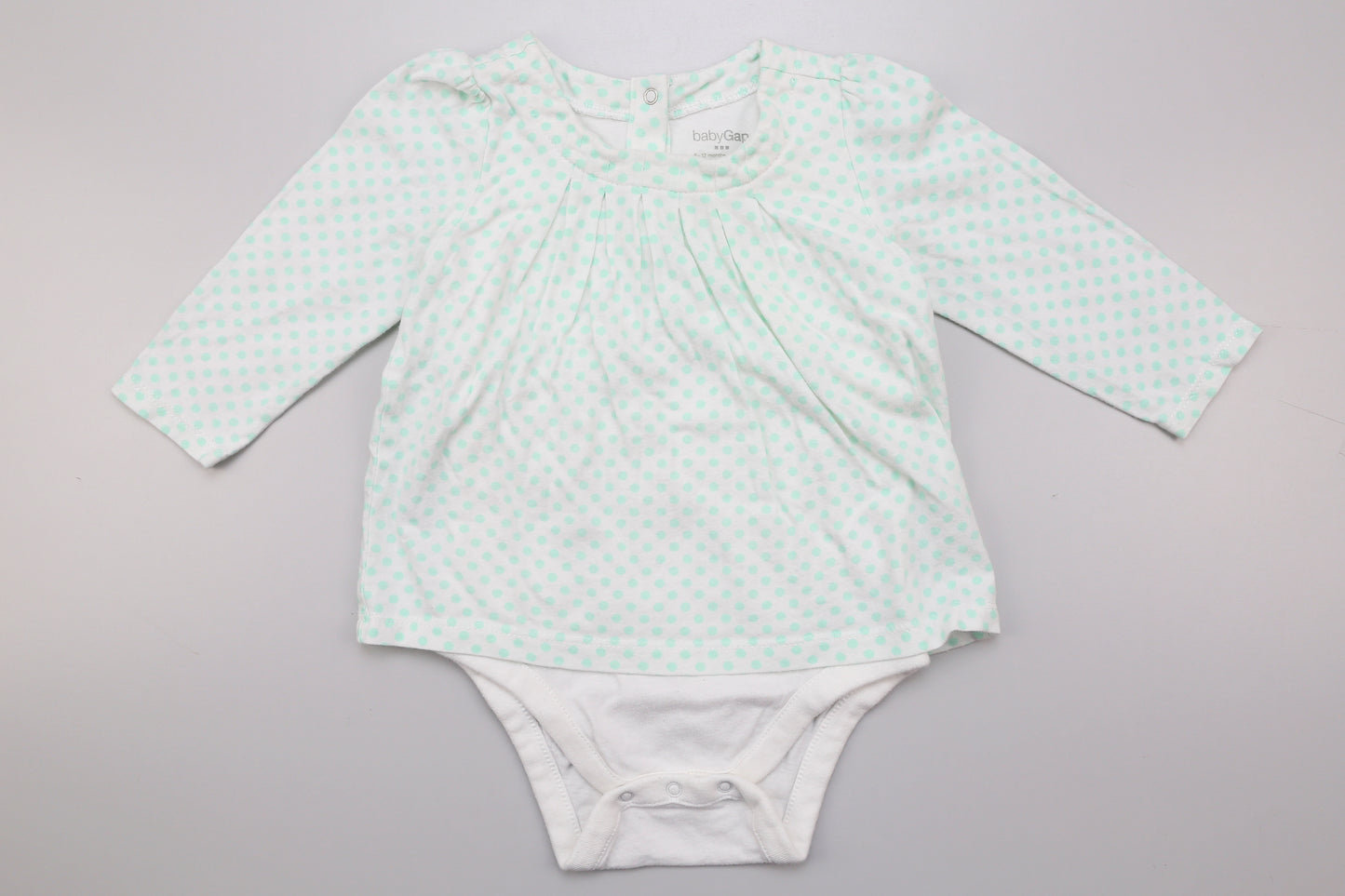 Grünes gepunktetes Langarm-Bodykleid für Mädchen.