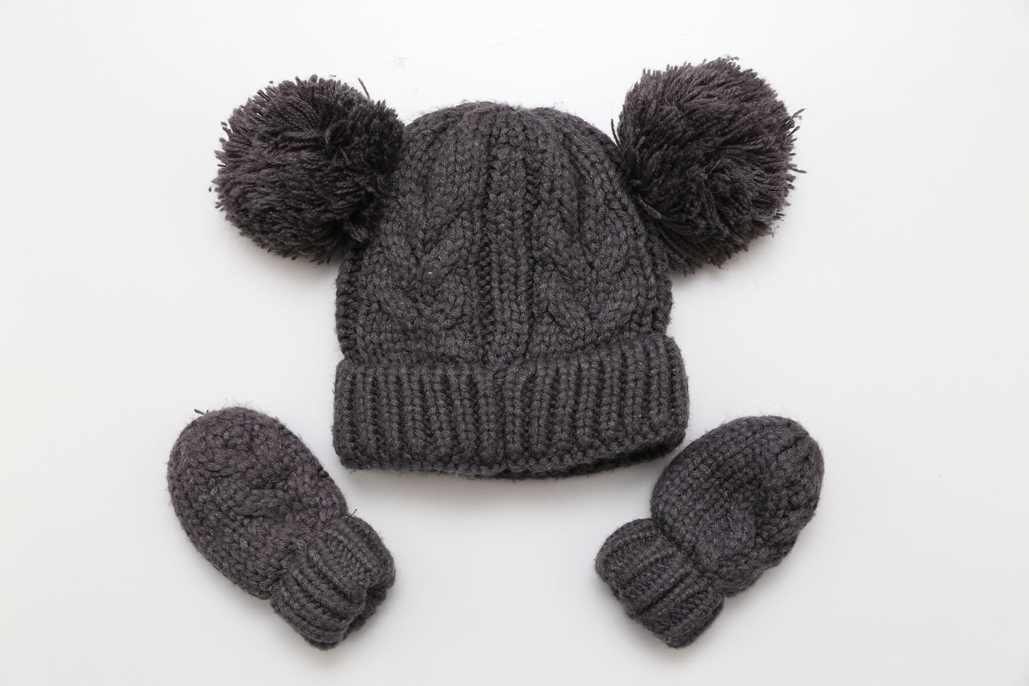 Strickmütze mit Bommel und passenden Fäustlingen.