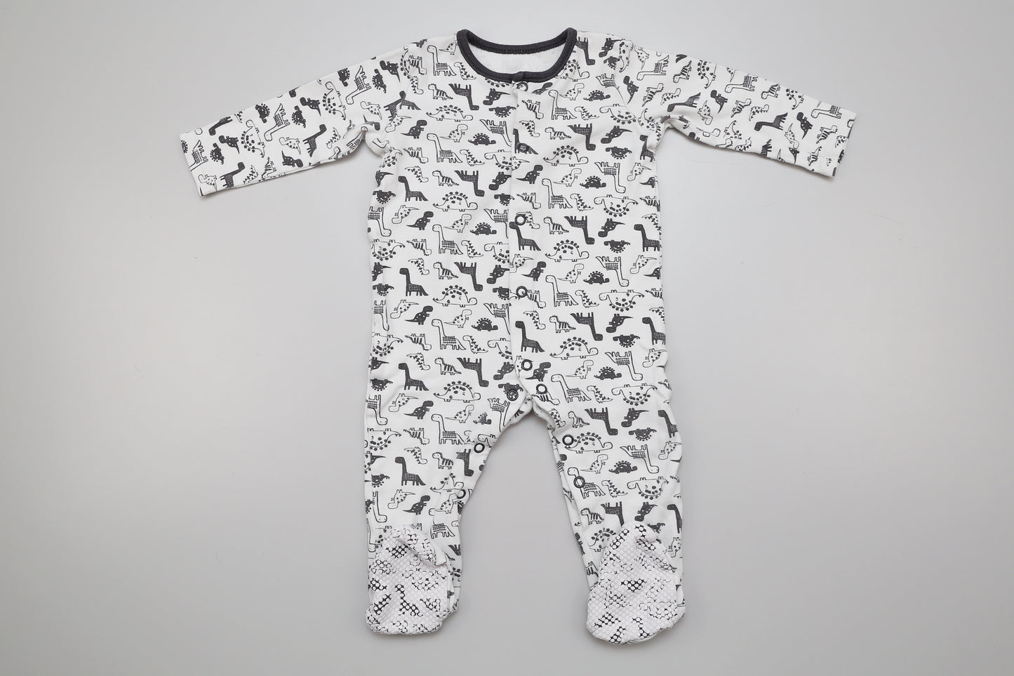 Schwarz-weißer Baumwollstrampler mit Dinosauriermuster. 80