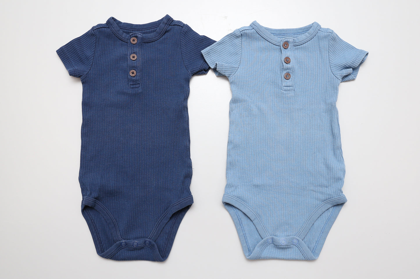 Blaues Kurzarm-Body-Set aus Bio-Baumwolle mit GOTS-Zertifizierung. Aus geripptem Material, vorne mit Knöpfen. 74-80