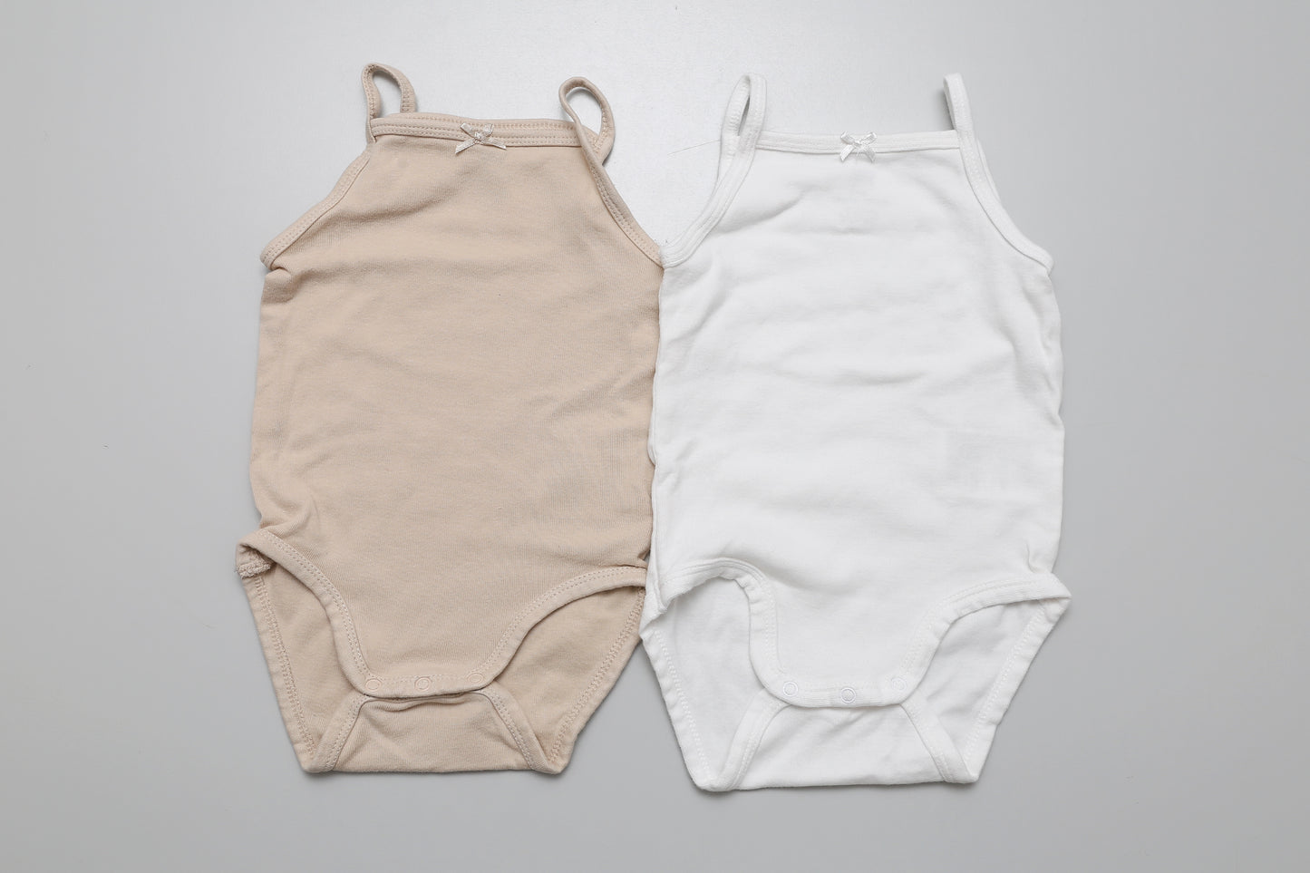 2er-Set ärmellose Bodys in Beige und Weiß aus Bio-Baumwolle für Mädchen in Größe 74. Ideal für den Alltag oder als Unterwäsche.