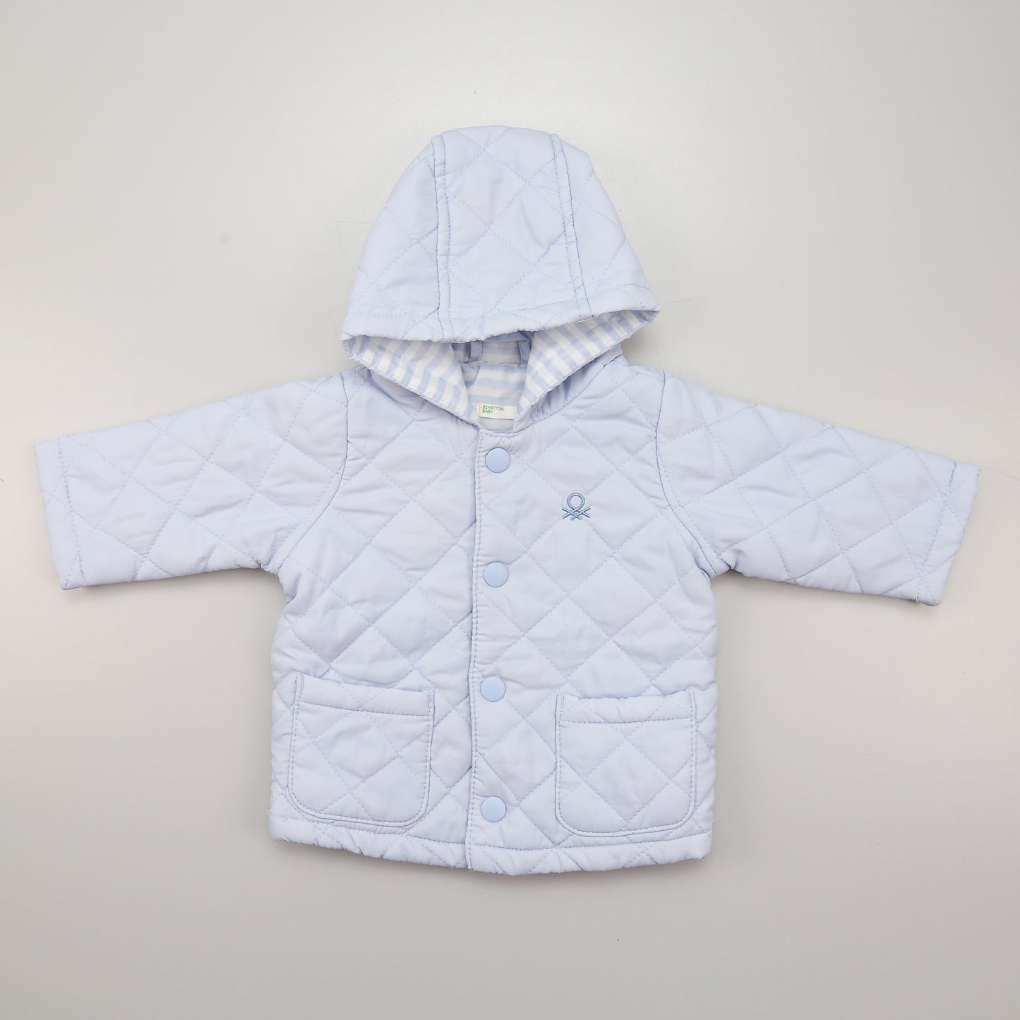 Szteppelt Übergangsjacke in Hellblau mit Kapuze, vorne mit Druckknöpfen.