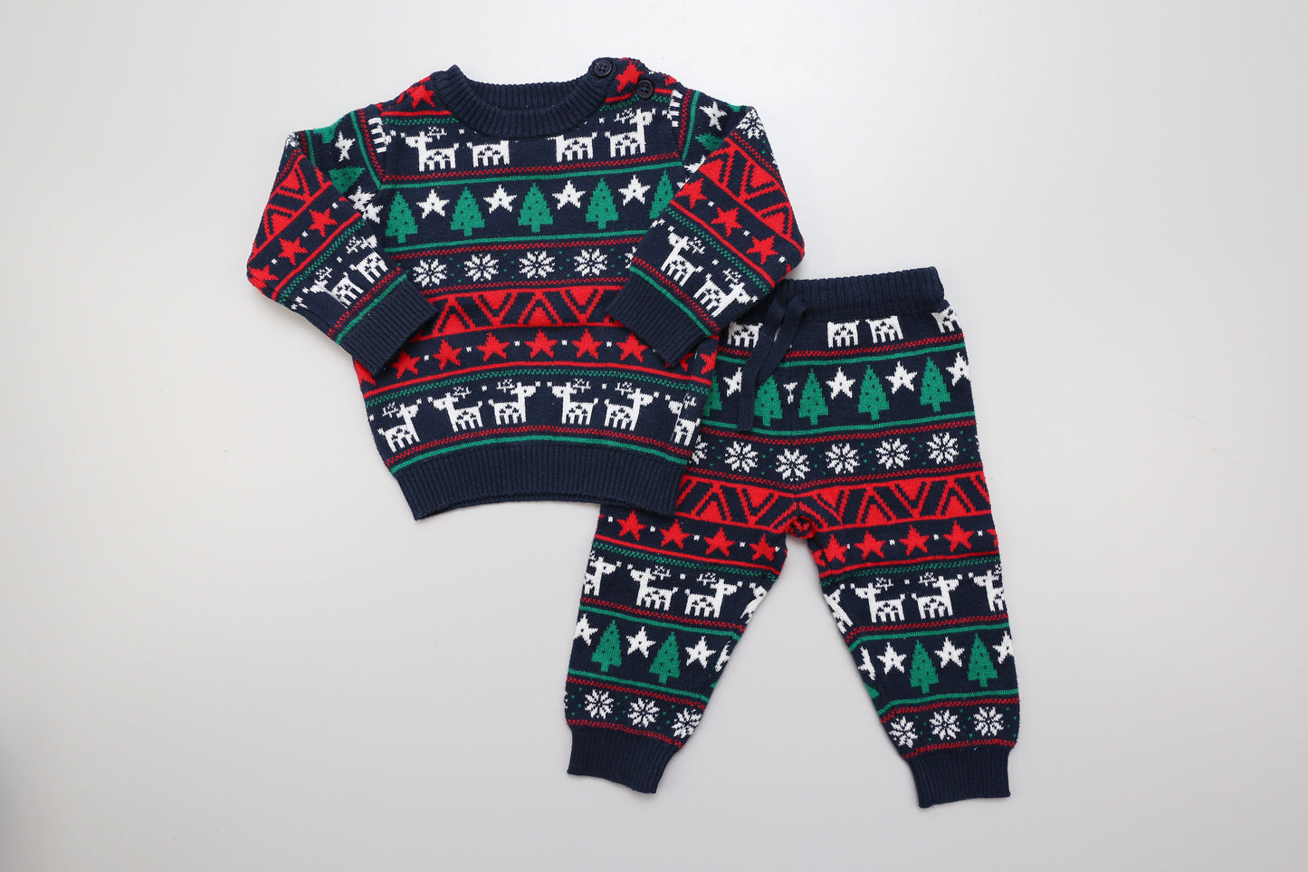 Weihnachtlich gemusterter Strickanzug mit zwei Knöpfen an der Schulter des Pullovers.