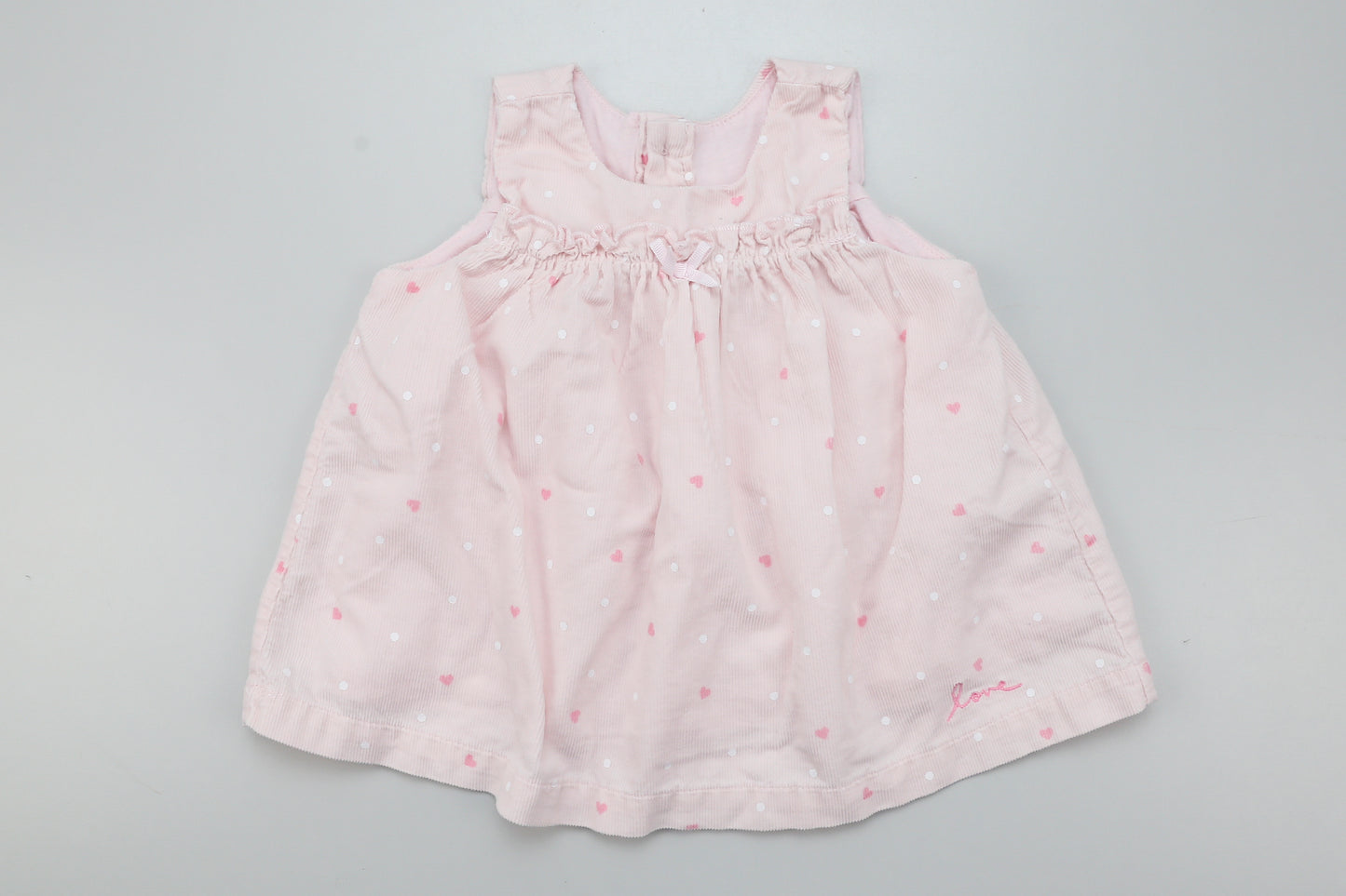 Ärmelloses rosa Cordkleid mit Knöpfen auf der Rückseite.