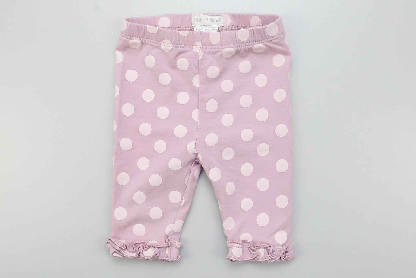 Lila Leggings mit Punkten und Rüschen an den Beinen.
