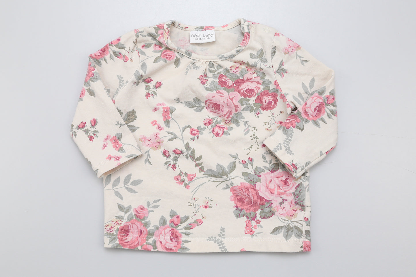 Geblümtes Langarmshirt von Next mit Druckknopf am Halsausschnitt.