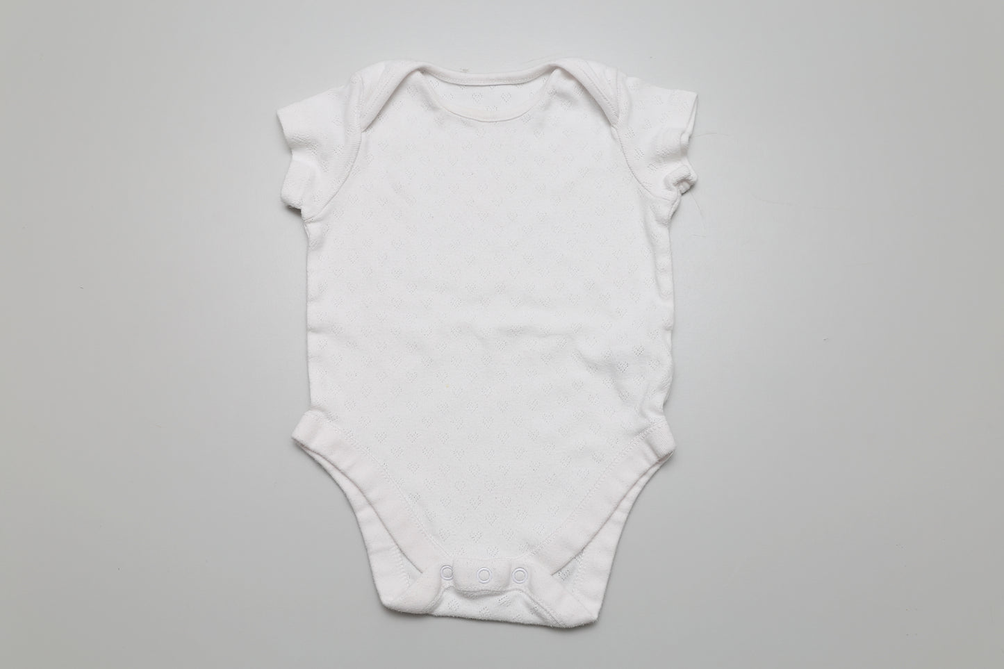 Weißer kurzärmeliger Body aus Baumwolle. Perfekt für jede Jahreszeit und leicht zu kombinieren. Größe: 74.