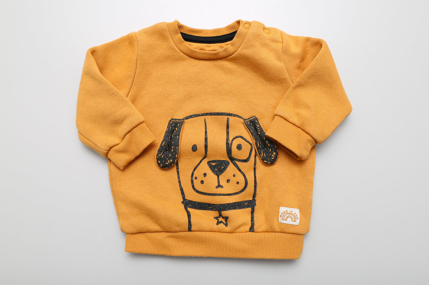 Gelbes Sweatshirt mit Hundemotiv in Größe 62. Mit zwei Druckknöpfen am Hals für einfaches Anziehen. Das Motiv ist leicht abgenutzt (siehe Bilder)