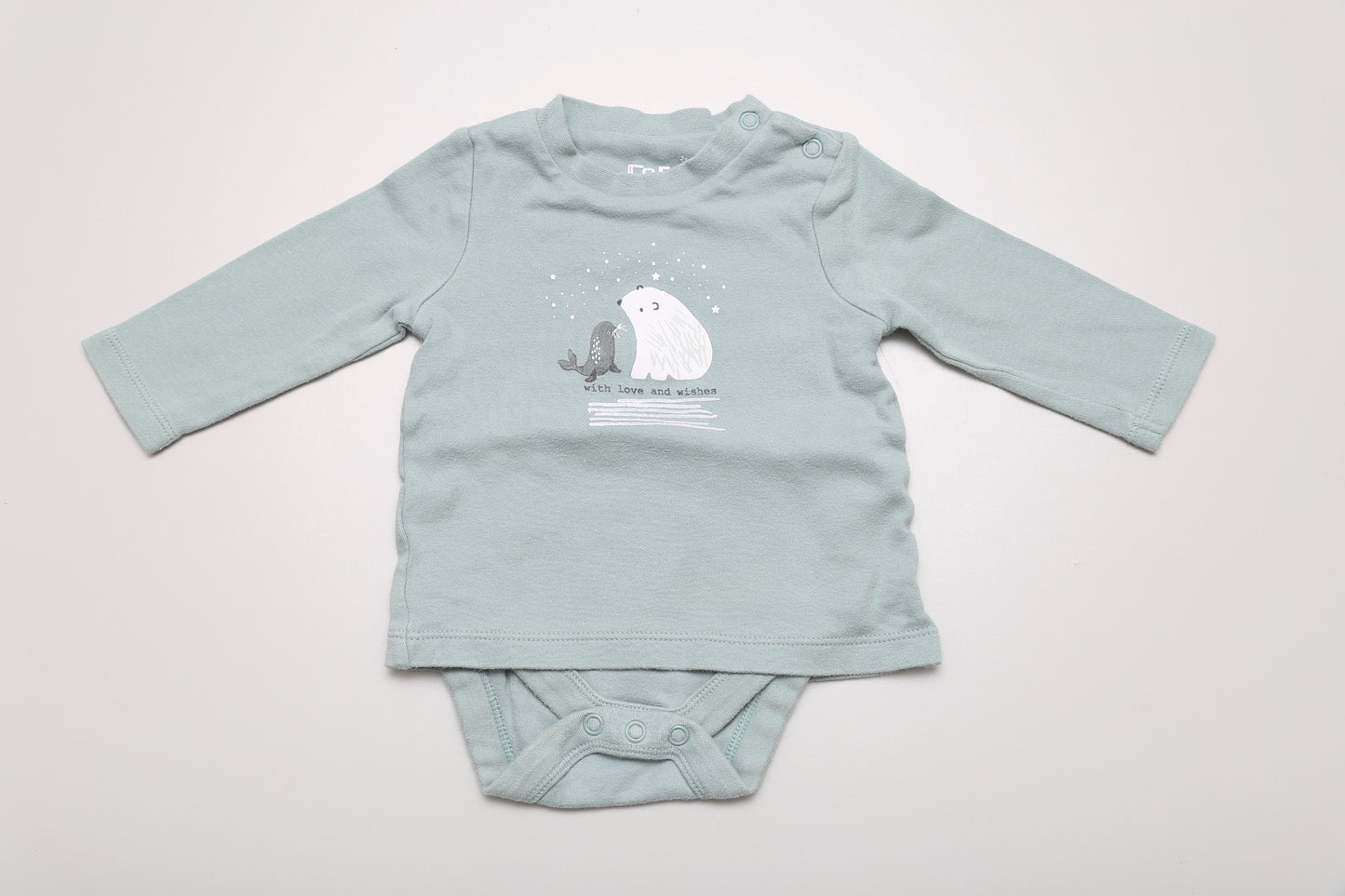 Hellgrünes T-Shirt-Body mit Eisbärenmotiv. Am Halsausschnitt mit Druckknöpfen zu öffnen. 100 % Baumwolle, Größe 62. Minimal waschpilling vorhanden.