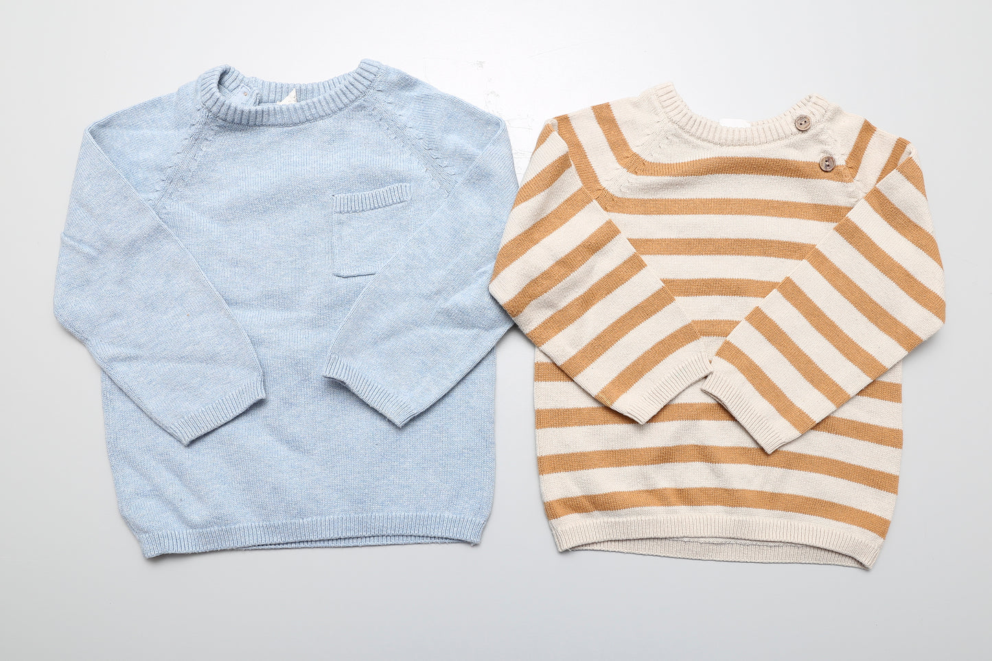 2-teiliges Strickpullover-Set für Jungen in Größe 86. Der braune Pullover hat vorne, der blaue hinten zwei Knöpfe am Hals für ein leichteres Anziehen.
