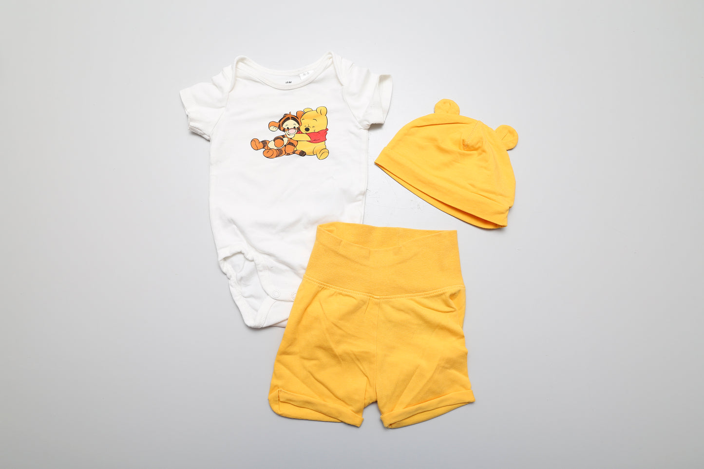 Winnie-the-Pooh-Set mit Kurzarmbody, kurzer Hose und Mütze aus Bio-Baumwolle. Größe 68.