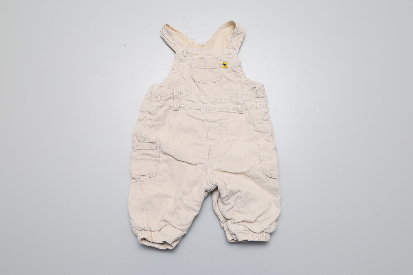 Beige gefütterte Latzhose aus Cordstoff. Unten mit Druckknöpfen zu öffnen. Größe 56.