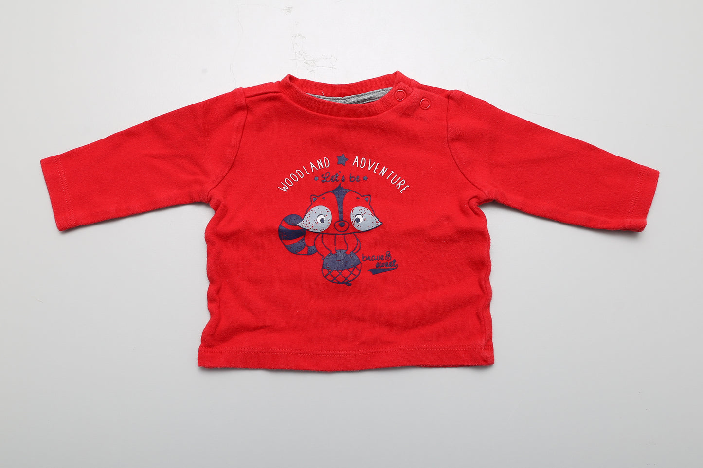 Rotes Langarmshirt mit Eichhörnchen-Motiv. Am Hals mit Druckknöpfen. Größe 56.
