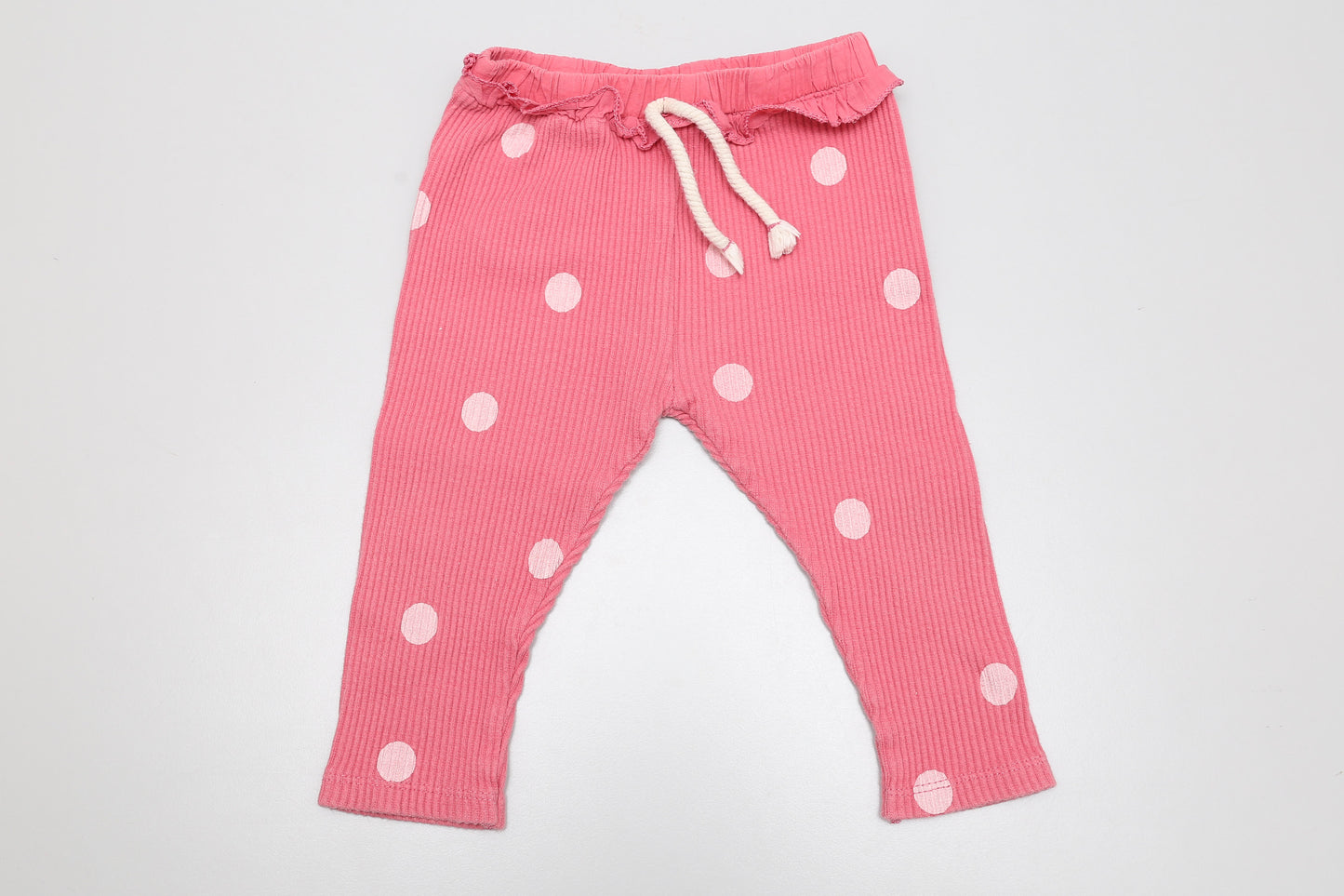 Rosa gepunktete Mädchenhose mit Rüschen. Größe 68.