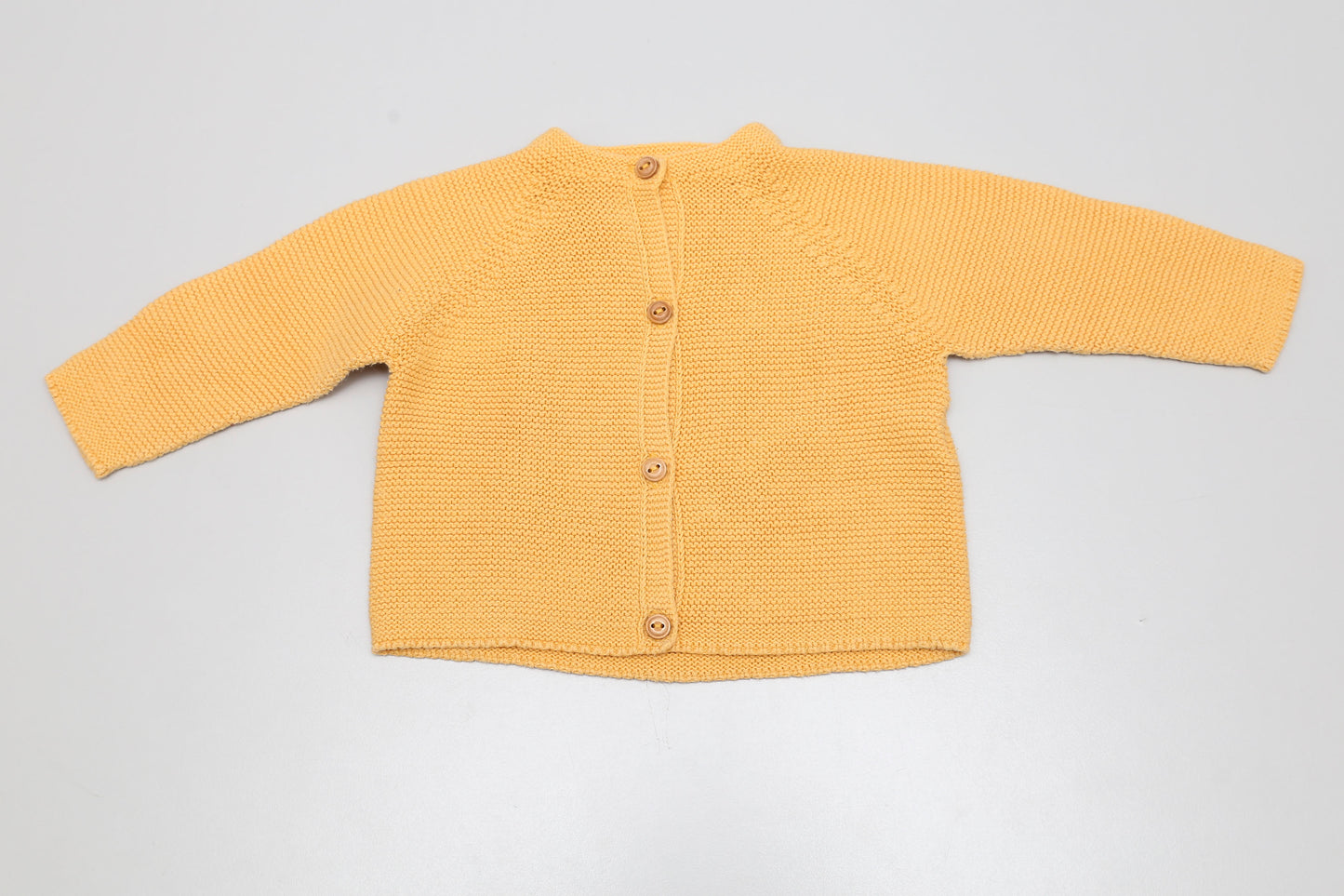 Senfgelber Strickcardigan für Mädchen.
