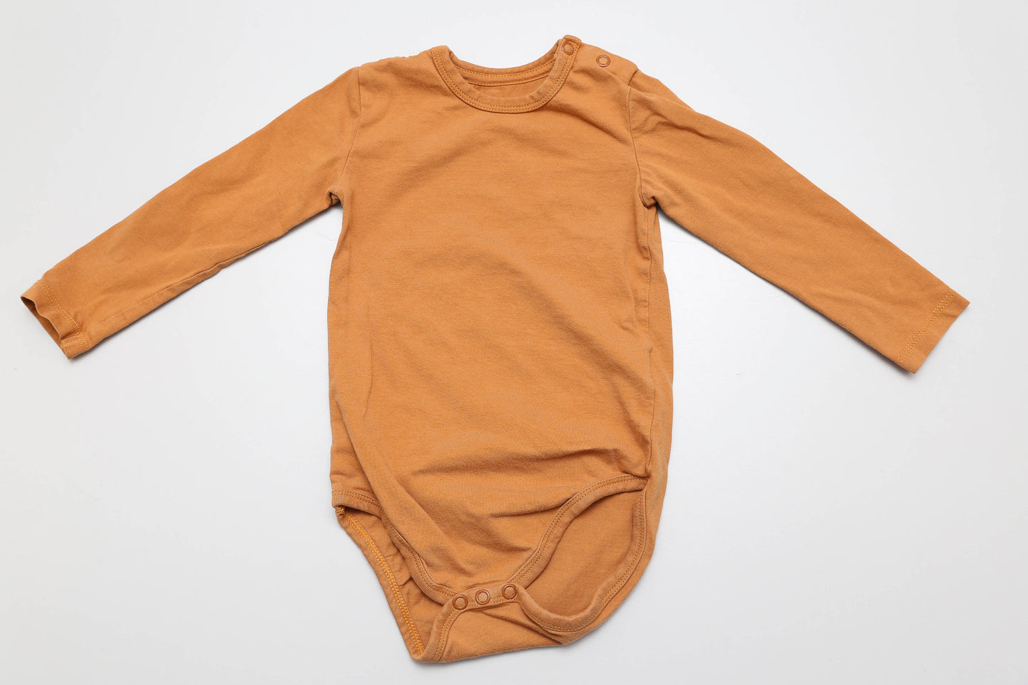 Bequemer, brauner Langarm-Body aus weicher, organischer Baumwolle. Die Druckknöpfe an der Schulter sorgen für ein unkompliziertes An- und Ausziehen – ideal für den Alltag mit Baby. In Größe 80 erhältlich.