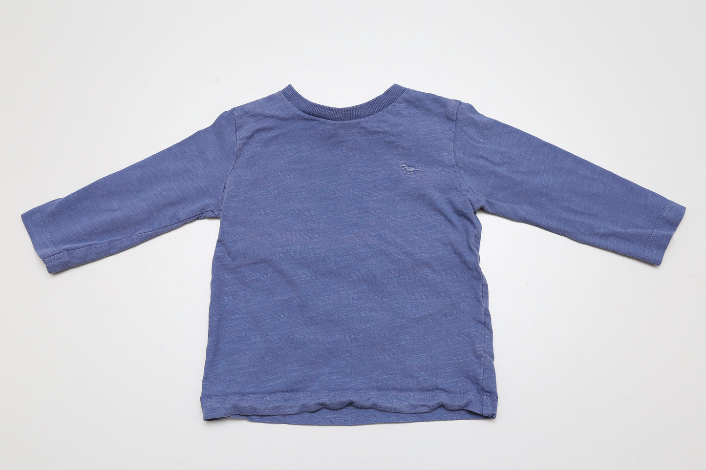 Weiches, langärmliges Shirt aus 100 % Bio-Baumwolle – in schönem Blau und mit einer liebevollen, kleinen Dino-Stickerei auf der Brust. Sanft zur Haut und perfekt für kleine Entdecker im Alltag.