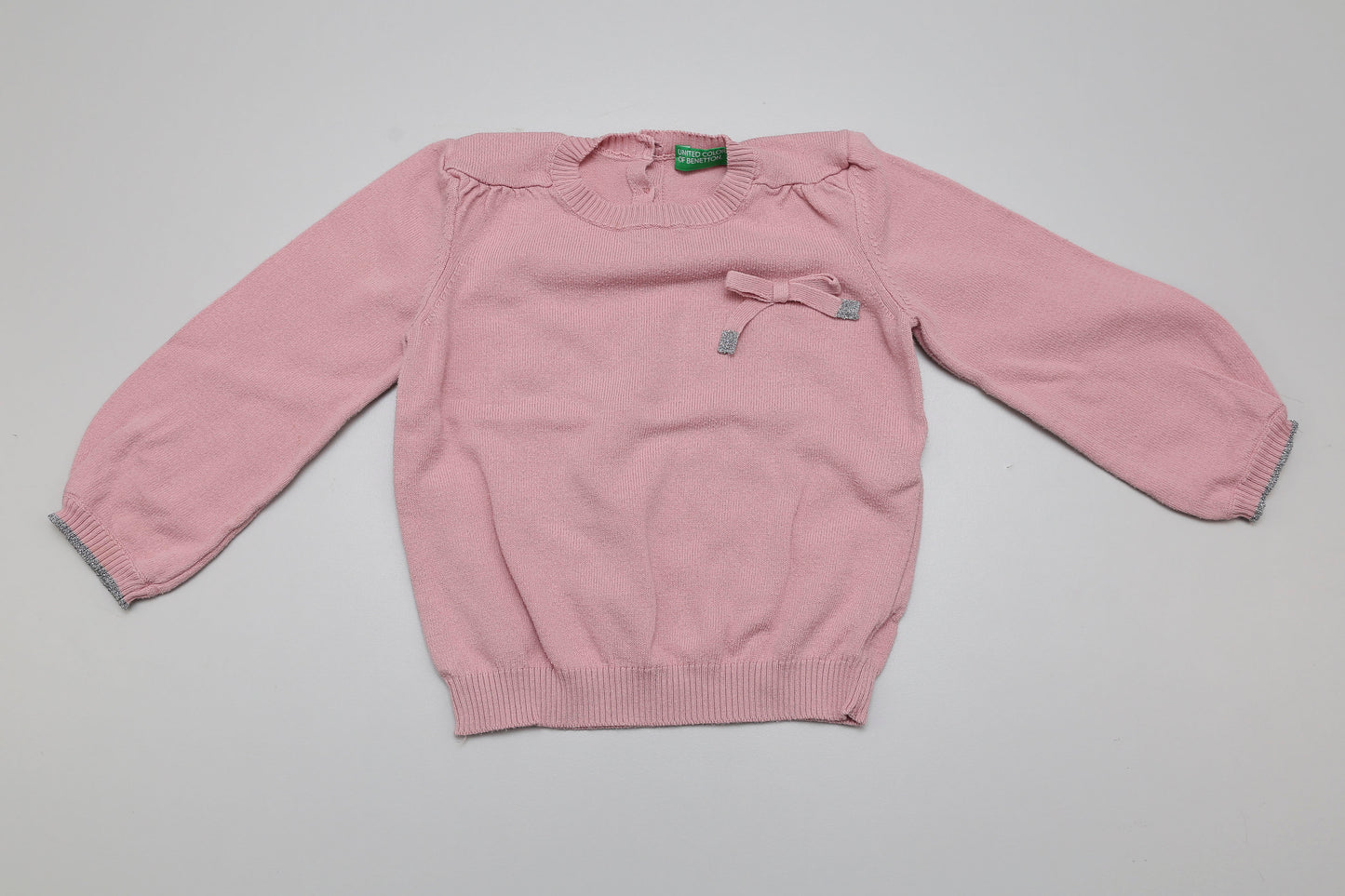 Süßer, weicher Strickpullover in zartem Rosa mit einer kleinen Schleife auf der Vorderseite. Größe 80/86. Ein wenig Waschpeeling ist vorhanden, der Pullover ist aber weiterhin kuschelig und tragbar.