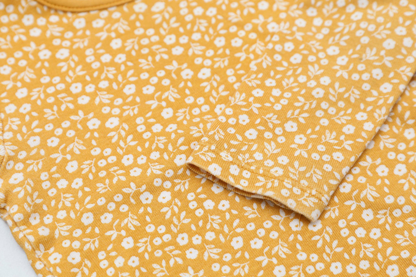 Gelbes Langarmshirt mit Blumenmuster und Schulterknöpfen (68-74)
