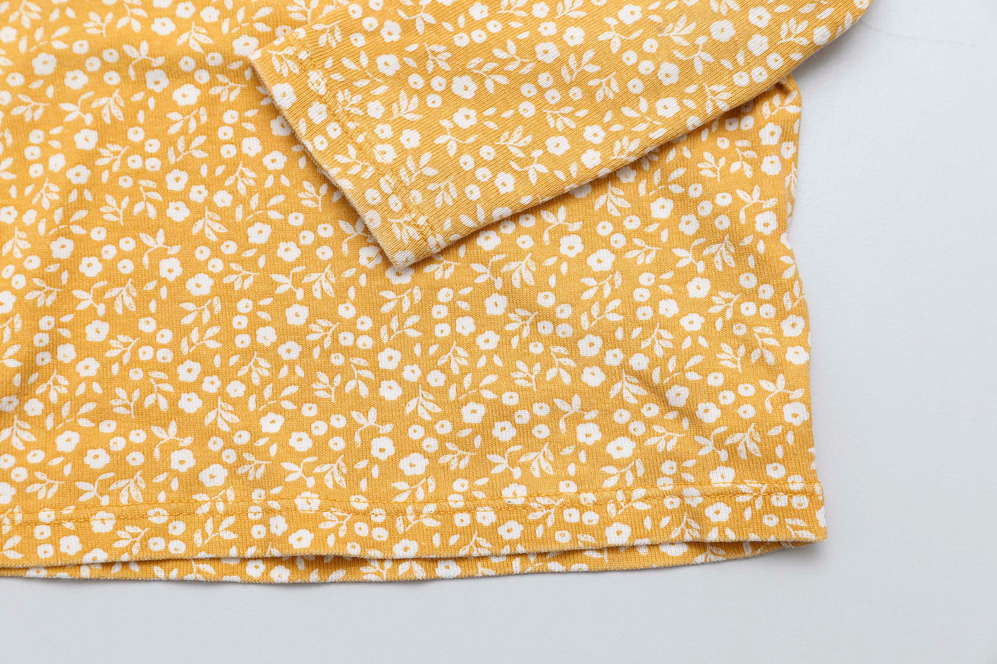 Gelbes Langarmshirt mit Blumenmuster und Schulterknöpfen (68-74)