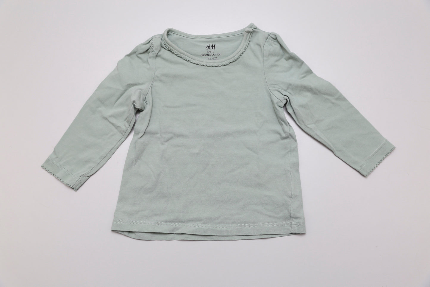 Sanftes hellgrünes Langarmshirt für Mädchen in Größe 74 – aus 100 % Bio-Baumwolle. Mit praktischem Druckknopf an der Schulter für einfaches Anziehen. Weich, hautfreundlich und nachhaltig.