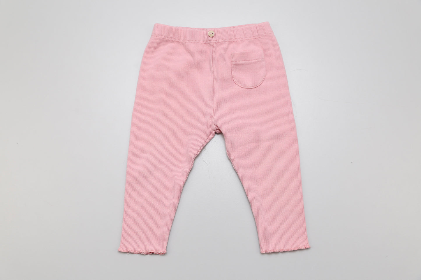 Stylische rosa Baby-Leggings aus geripptem Stoff von Zara für Mädchen in Größe 68. Mit dekorativem Knopf und kleiner Vordertasche – bequem, weich und ideal für den Alltag.