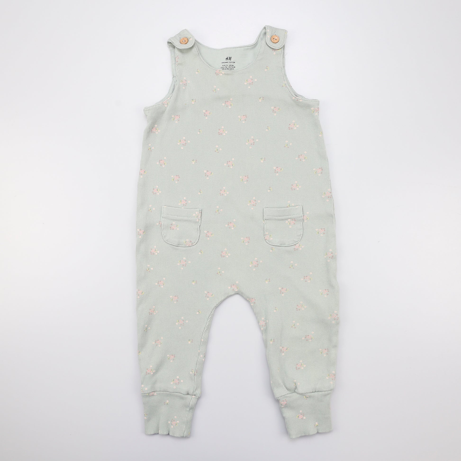 hellgrüne Latzhose mit kleinen Blumenmuster und Knöpfen oben