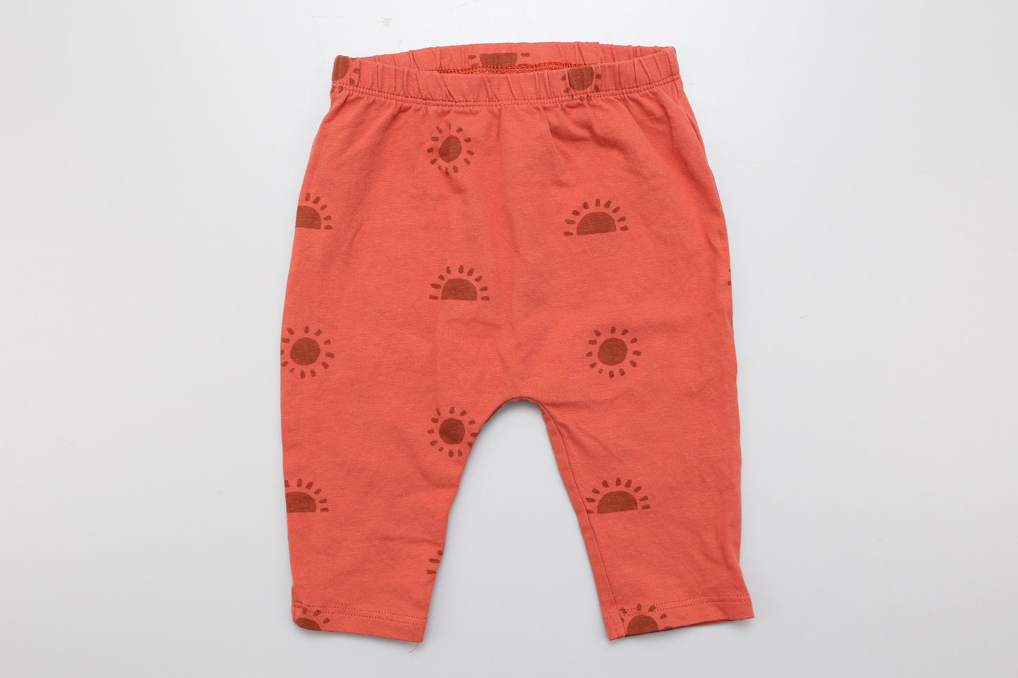 Ziegelroter Hosen mit Sonnenmotiv und weitem Schritt. Aus dünnem Material.  62-68