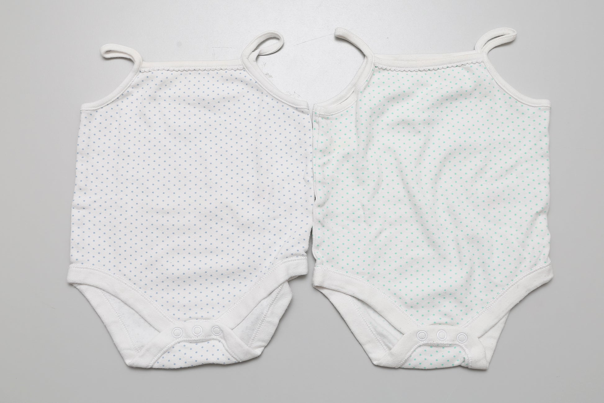 2-teiliges Set mit gepunkteten ärmellosen Bodys für Mädchen in Größe 74. Etwas kürzer und breiter geschnitten. Aus 100% Baumwolle.