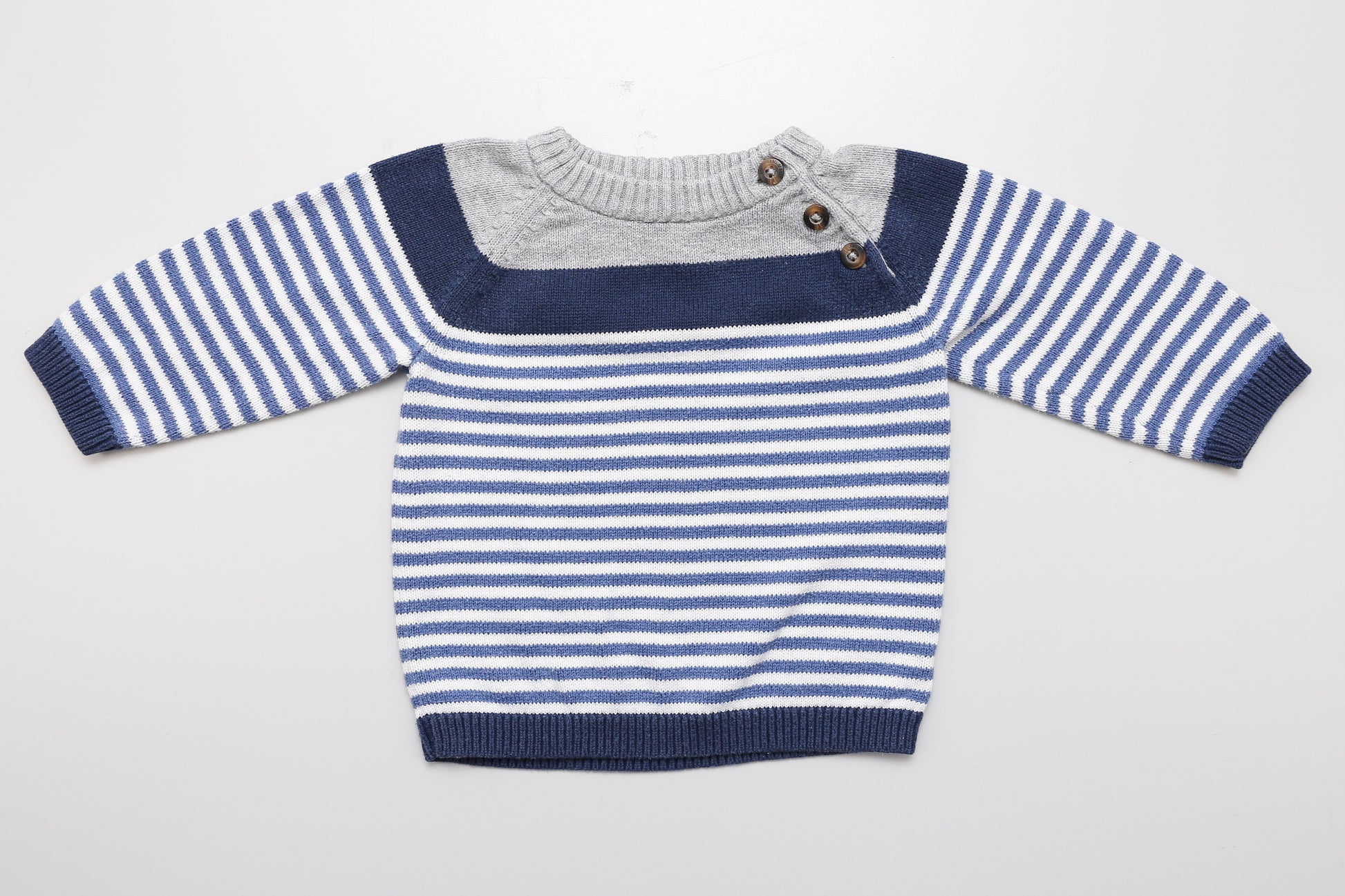 Blau-weiß gestreifter Strickpullover mit drei Knöpfen am Halsausschnitt.