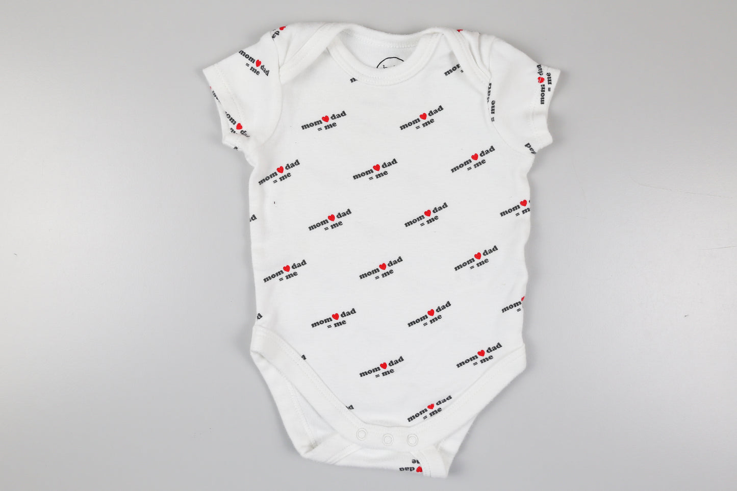 Weißer Kurzarmbody mit der Aufschrift ‚mom❤️dad=me’