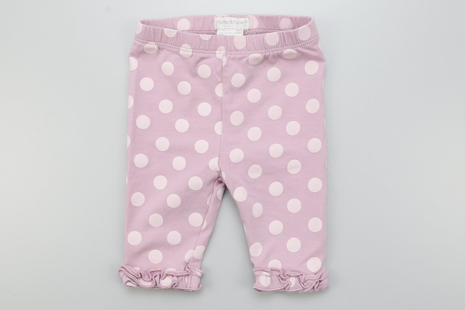 Lila Leggings mit Punkten und Rüschen an den Beinen.