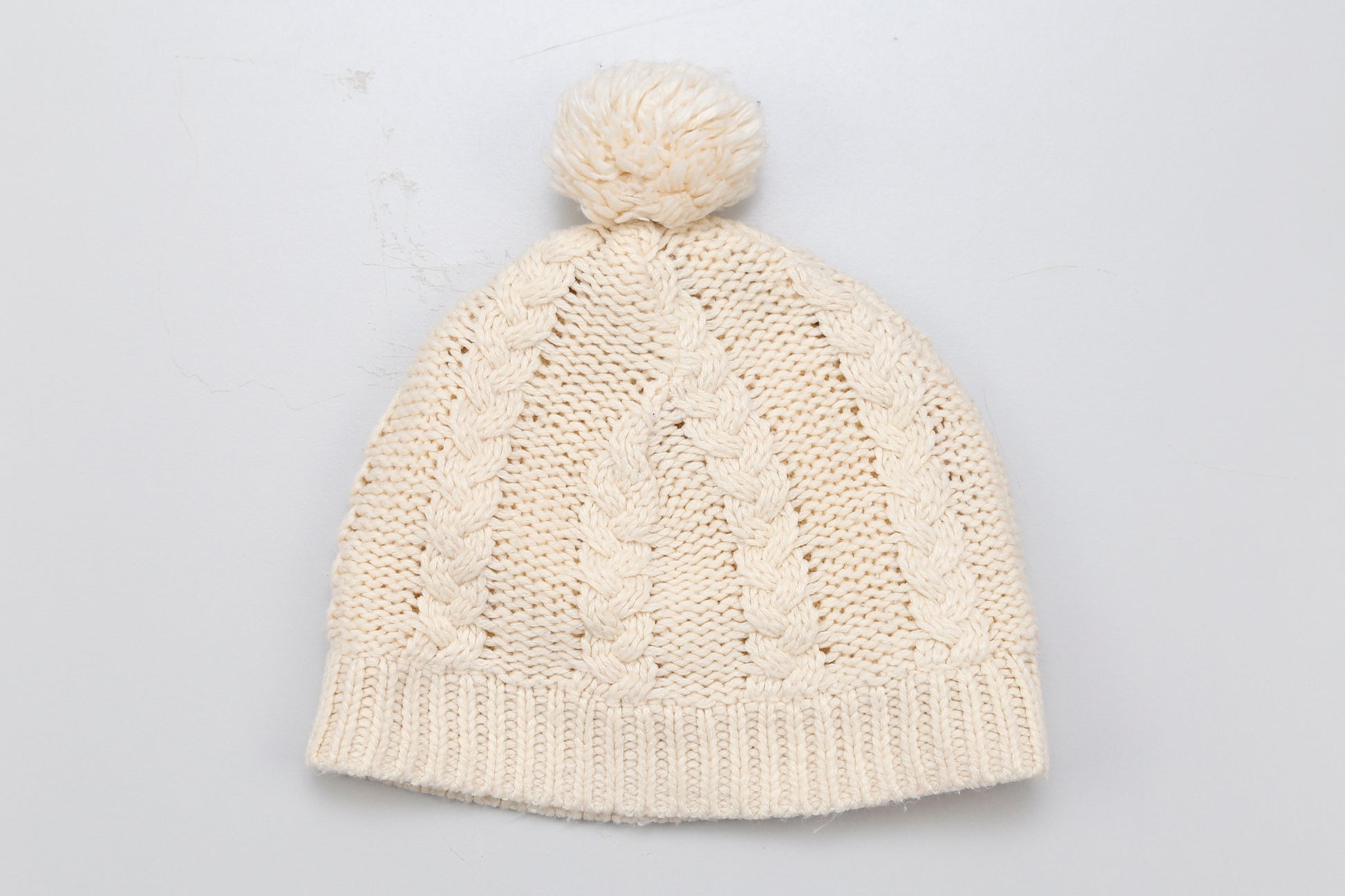 Gestrickte Beanie-Mütze in Beige mit Bommel