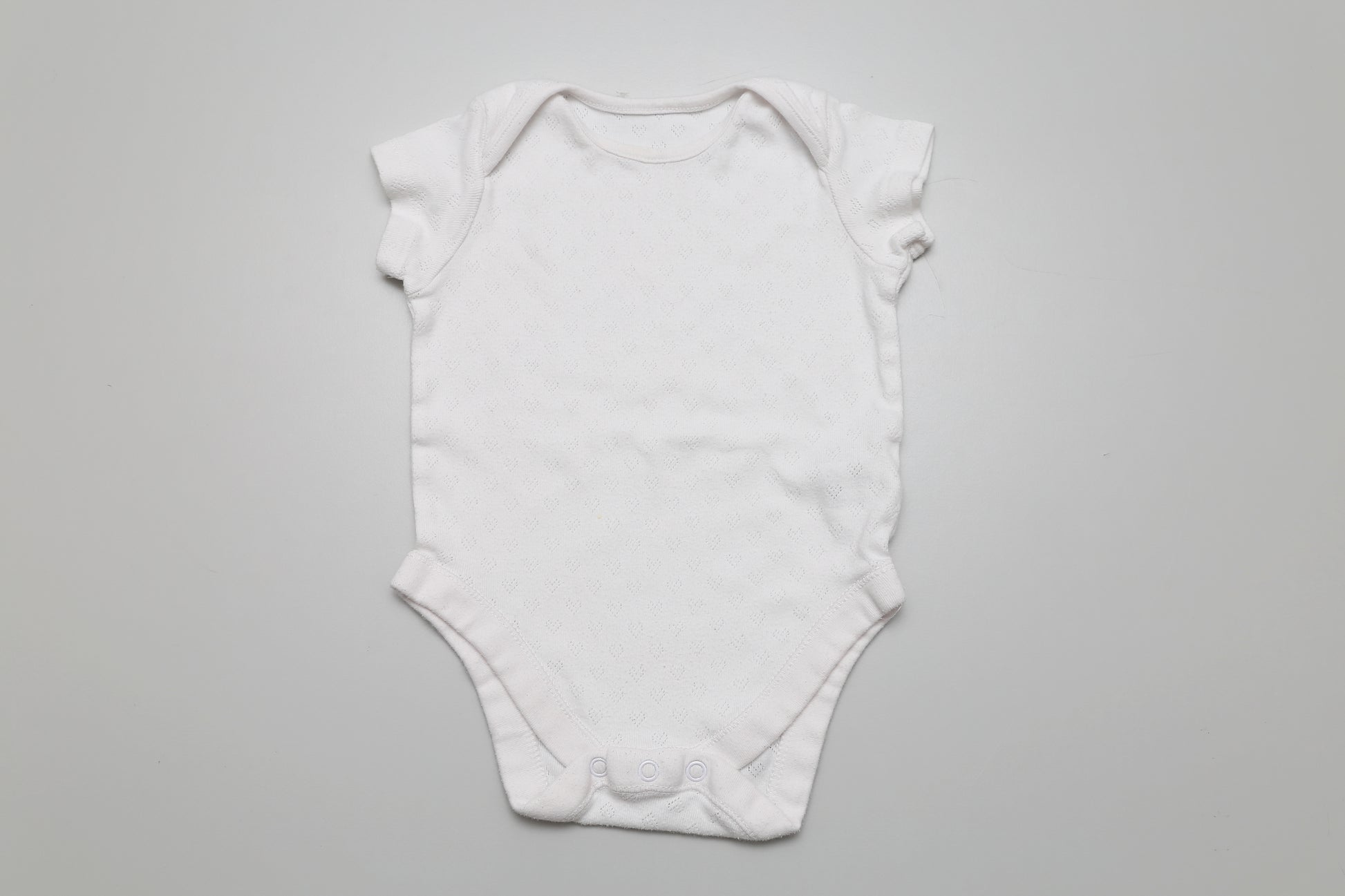 Weißer kurzärmeliger Body aus Baumwolle. Perfekt für jede Jahreszeit und leicht zu kombinieren. Größe: 74.