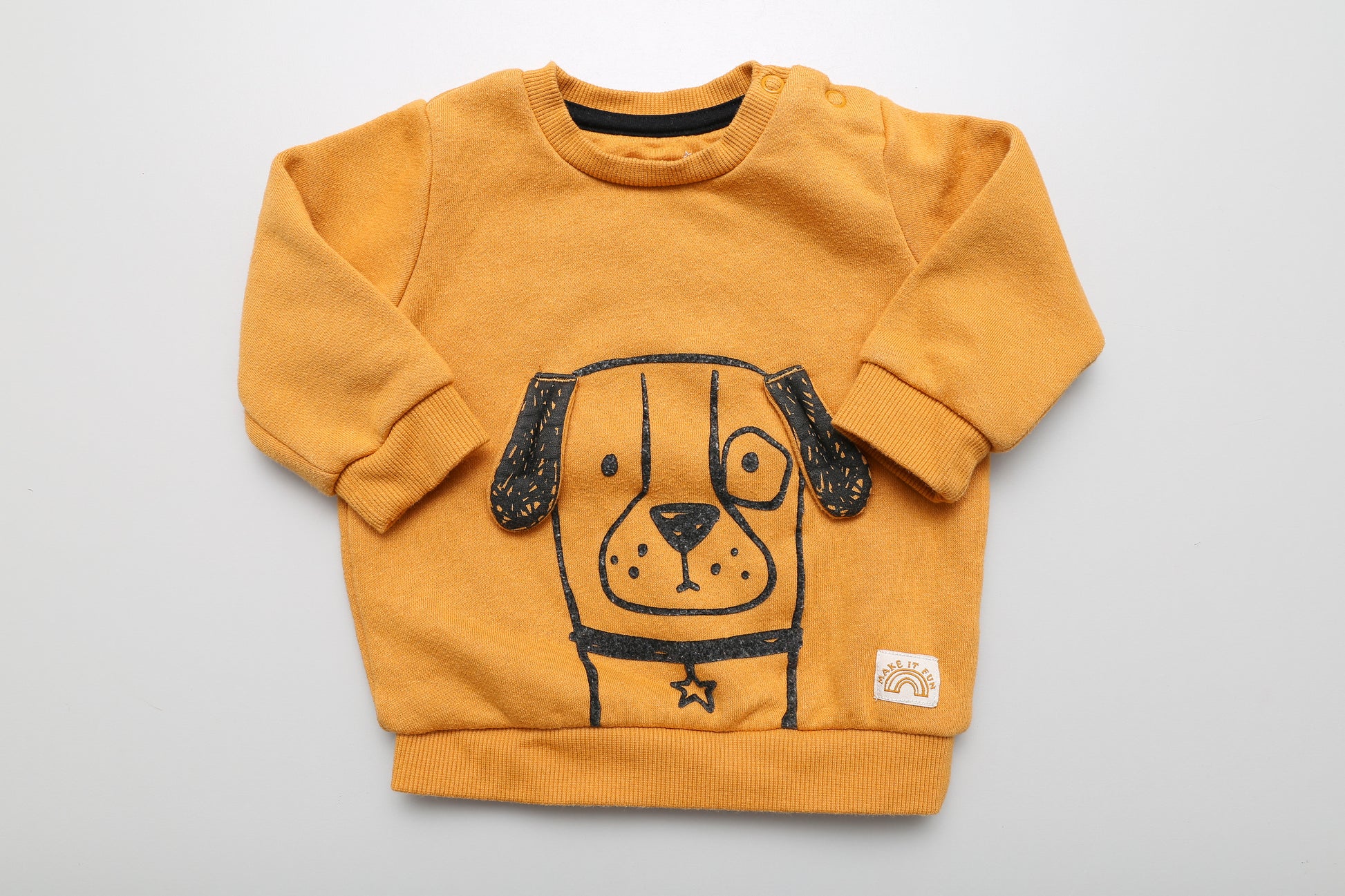 Gelbes Sweatshirt mit Hundemotiv in Größe 62. Mit zwei Druckknöpfen am Hals für einfaches Anziehen. Das Motiv ist leicht abgenutzt (siehe Bilder)