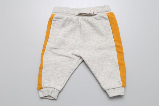 Bequeme hellgraue Jogginghose mit gelben Streifen in Größe 62. Perfekt für kleine Jungen zum Spielen und Entdecken!