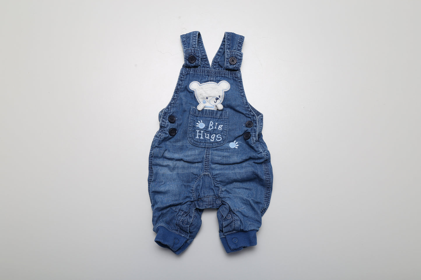 Latzhose aus Jeansstoff mit Bärenmotiv. Unten mit Druckknöpfen zu öffnen. Größe 50-56.