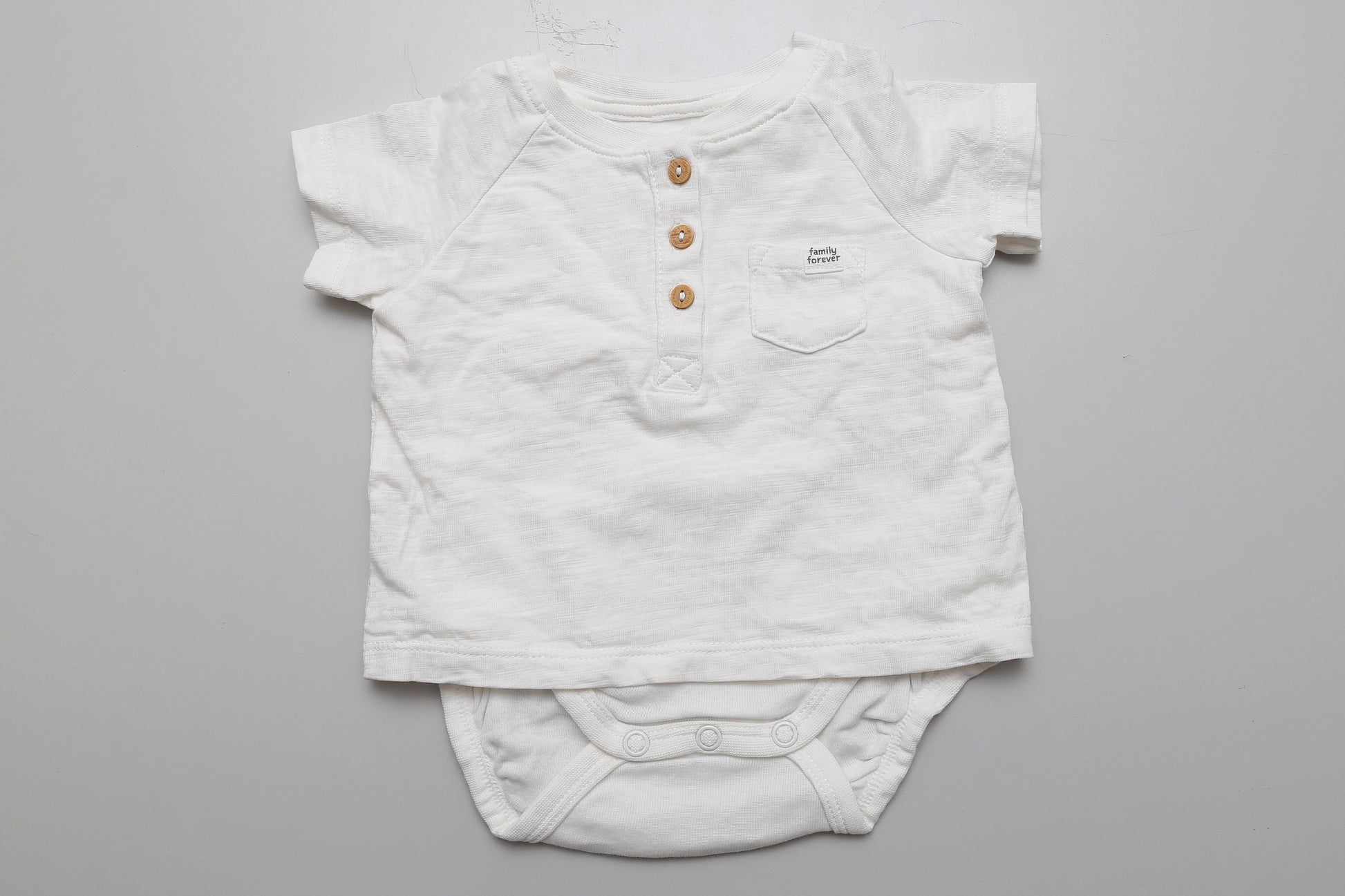 Weißer Polo-Body aus 100 % Baumwolle mit drei Knöpfen vorne. Größe 56.