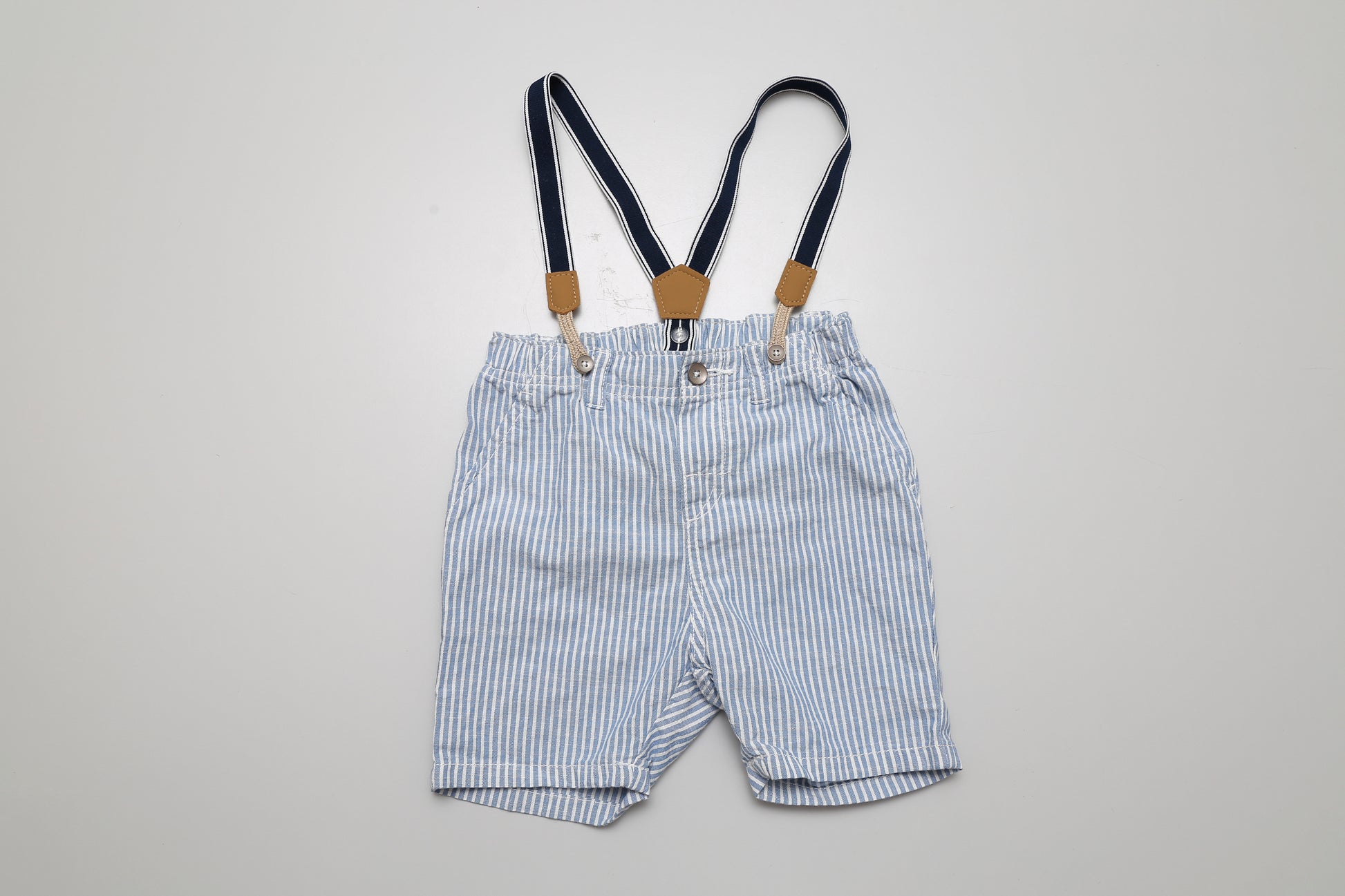Blau-weiß gestreifte Shorts mit abknöpfbaren Trägern. Aus 100 % Baumwolle, Größe 92.