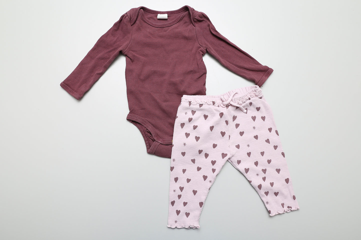 Lila Body-Leggings-Set in Größe 68. Das Body ist von H&M, die Leggings mit Herzchenmuster von Zara.